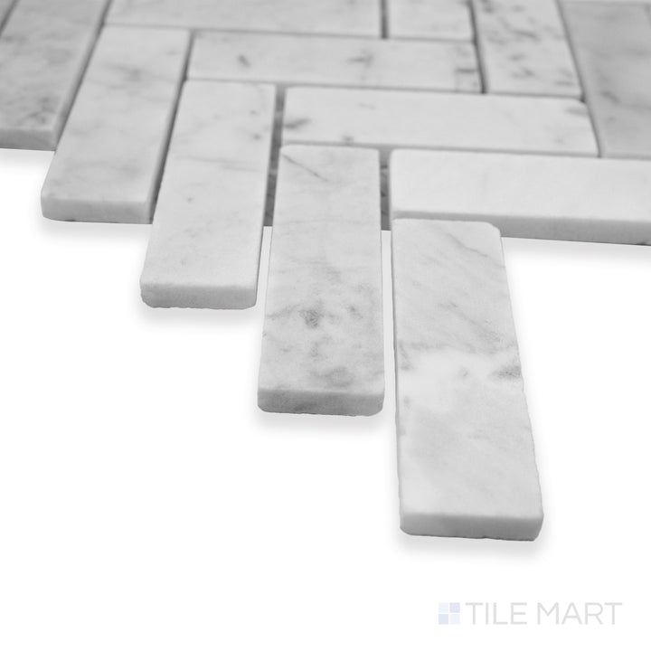 Rockart Carrara Herringbone polished marble mosaic in a corner shot, highlighting its classic herringbone pattern and luxurious white marble veining.