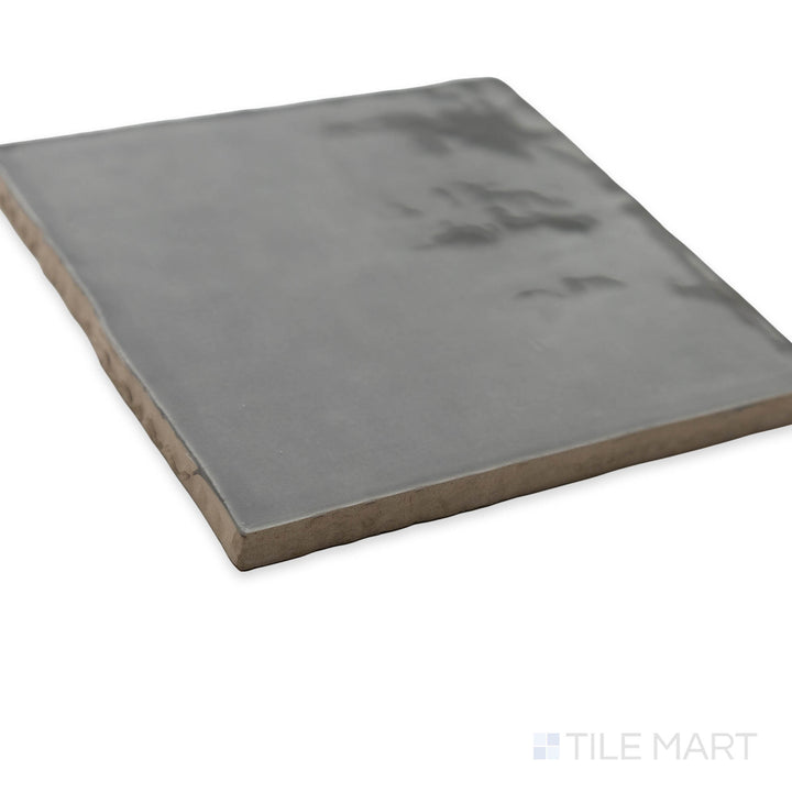 A sophisticated corner view of St. Tropez Gris 5x5 bright ceramic tile, featuring its subtle gray tones and polished surface for a refined aesthetic.