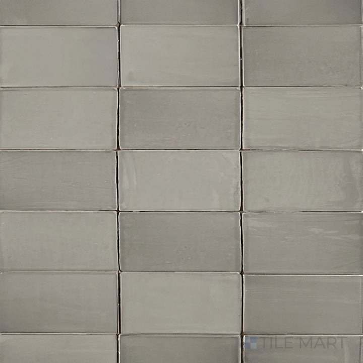 An overhead view of the St. Tropez Gris 2.5x5 inch bright ceramic tile showcases its smooth gray tone and glossy finish, adding a sleek and modern touch to any space.