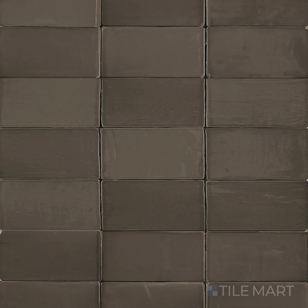 Seen from above, the St. Tropez Bronce 2.5x5 inch bright ceramic tile features a rich bronze shade with a polished glaze, adding depth and warmth to interior designs.