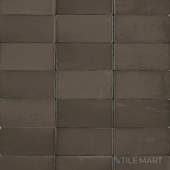 Seen from above, the St. Tropez Bronce 2.5x5 inch bright ceramic tile features a rich bronze shade with a polished glaze, adding depth and warmth to interior designs.