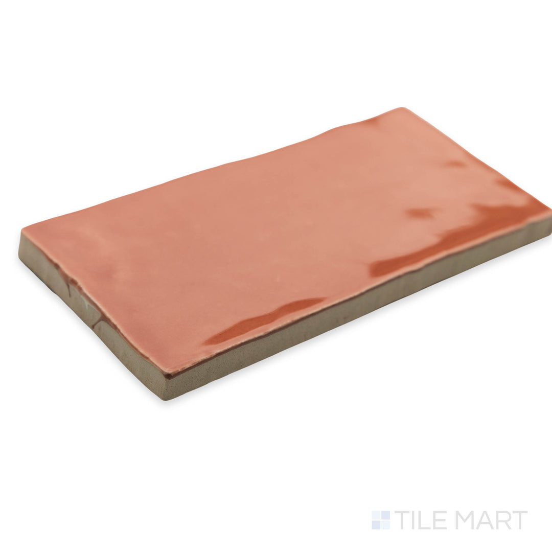 St. Tropez Coral 2.5x5 bright ceramic tile in a corner shot, emphasizing its soft coral hue and high-gloss finish for a warm, inviting feel.