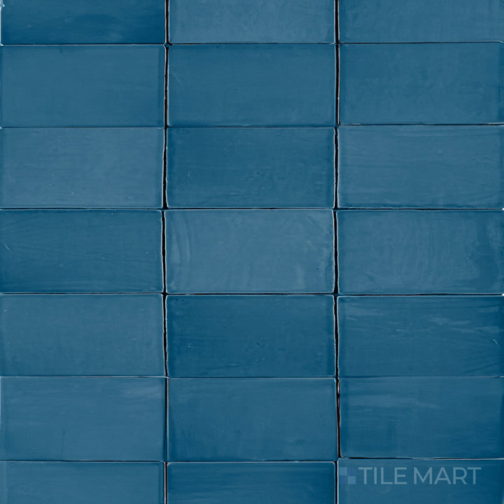 An overhead view of the St. Tropez Azul 2.5x5 inch bright ceramic tile highlights its bold blue tone and glossy sheen, creating a striking and refreshing aesthetic.