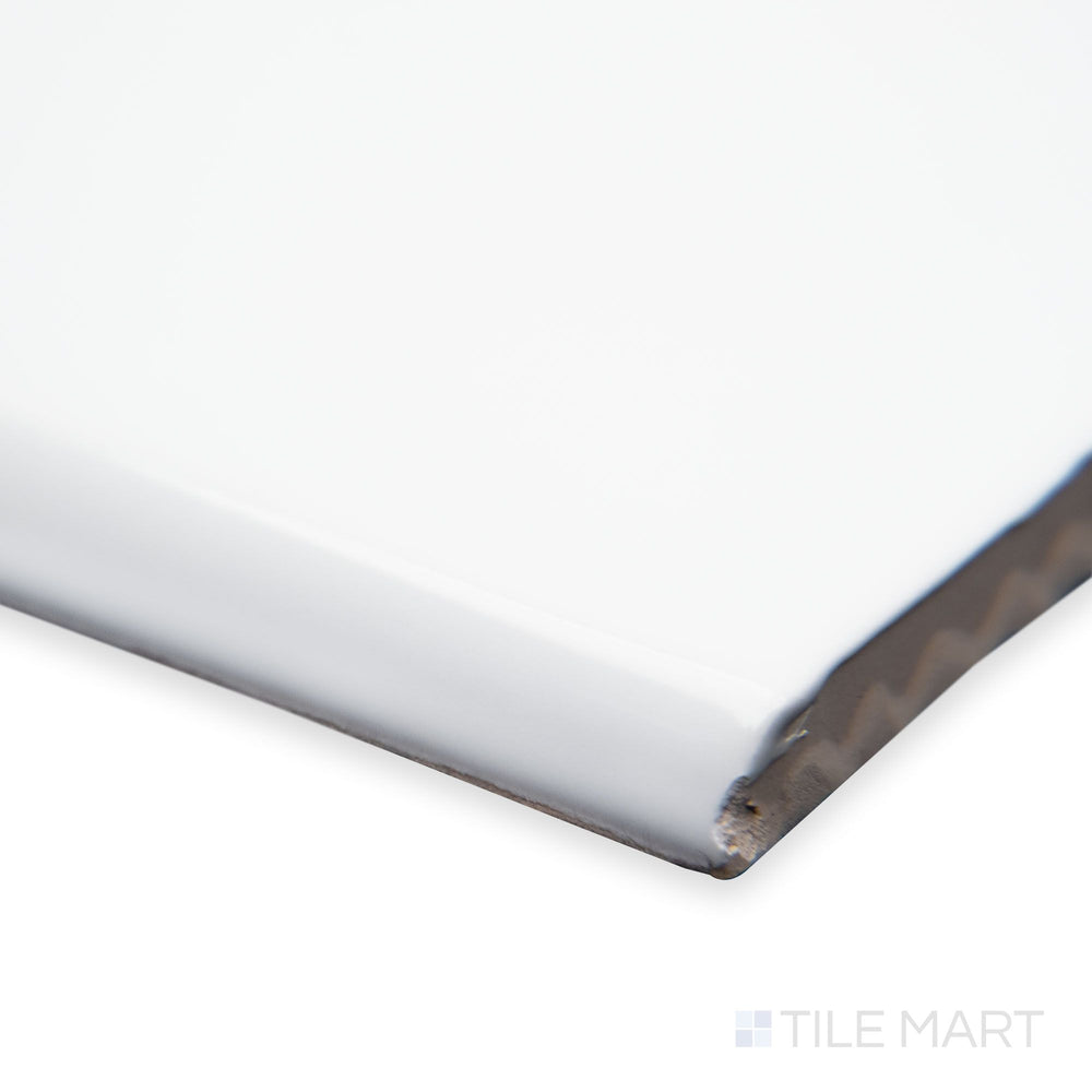 A close-up corner shot of St. Tropez Blanco 5x5 bright ceramic bullnose, showcasing its crisp white color, smoothly curved edge, and glossy finish.
