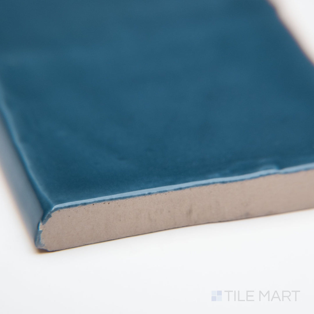 A detailed corner view of St. Tropez Azul 2.5x5 bright ceramic bullnose, showcasing its deep blue color, glossy ceramic glaze, and softly curved bullnose edge.