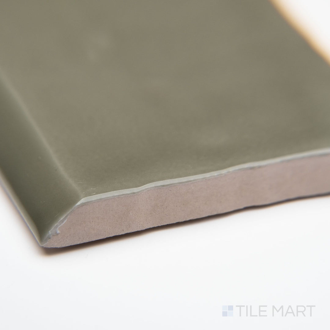 A close-up corner perspective of St. Tropez Verde 2.5x5 bright ceramic bullnose, highlighting its rich green tone, curved edge detail, and lustrous glazed surface.