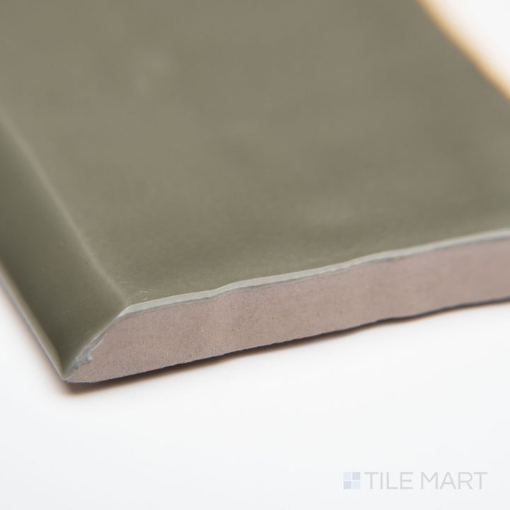 A close-up corner perspective of St. Tropez Verde 2.5x5 bright ceramic bullnose, highlighting its rich green tone, curved edge detail, and lustrous glazed surface.