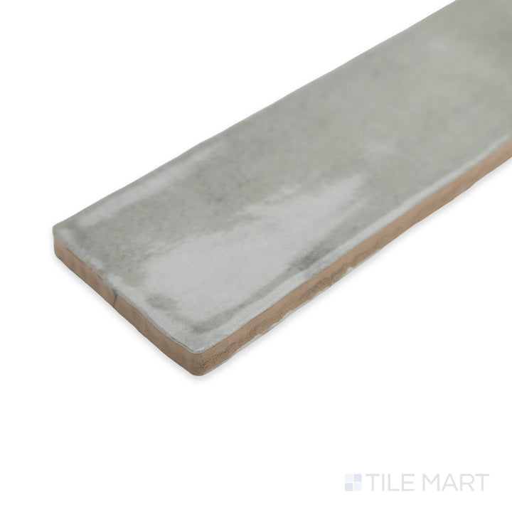 A refined corner view of Zellige Tender Gray 2x16 bright ceramic tile, featuring a soft neutral tone and a high-gloss glaze for a subtle yet elegant appeal.