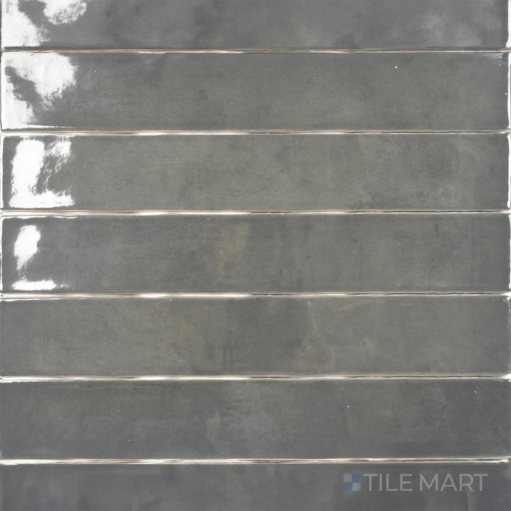 An overhead shot of the Zellige Dark Gray 2x16 inch bright ceramic tile emphasizes its deep gray color with a reflective glaze, creating a bold and contemporary statement.
