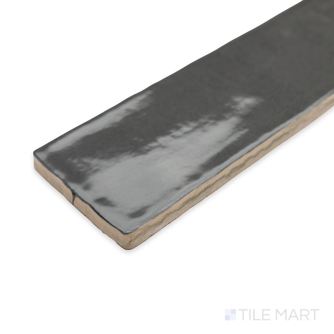 Zellige Dark Gray 2x16 bright ceramic tile captured in a stylish corner perspective, emphasizing its rich charcoal hue and reflective handcrafted finish.