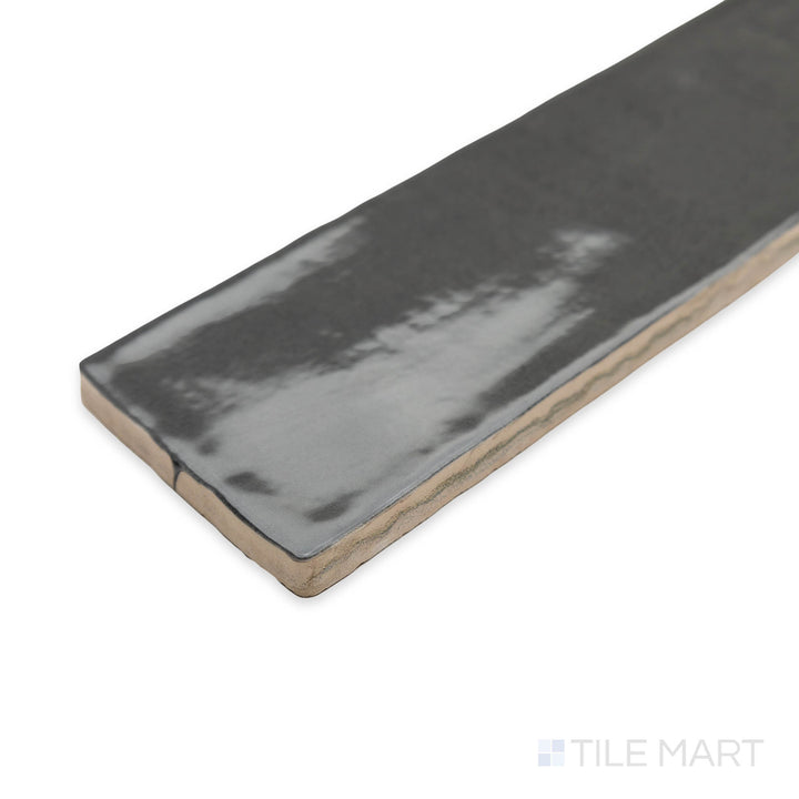 Zellige Dark Gray 2x16 bright ceramic tile captured in a stylish corner perspective, emphasizing its rich charcoal hue and reflective handcrafted finish.