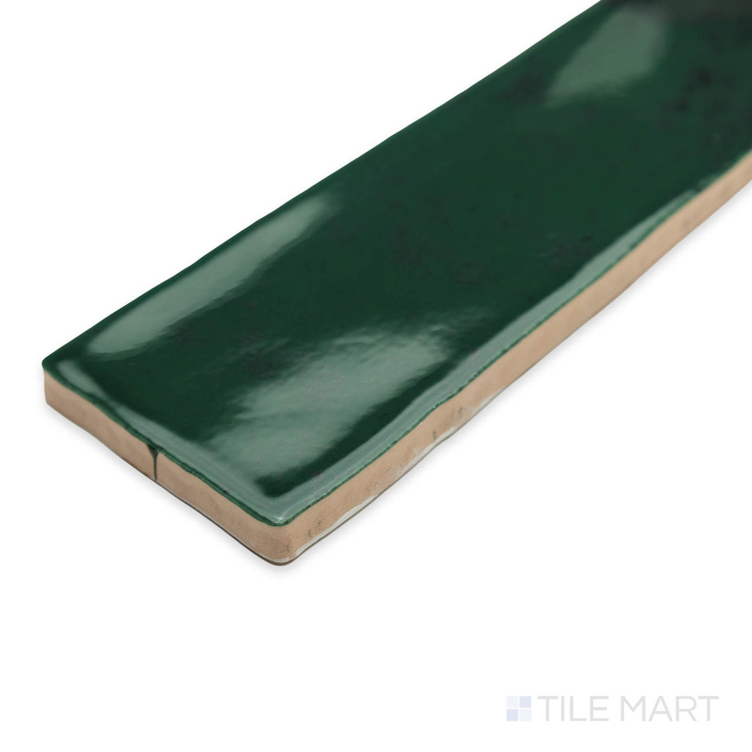 A vibrant corner shot of Zellige Emerald Green 2x16 bright ceramic tile, showcasing its deep green shade and glossy, slightly uneven surface for a natural feel.