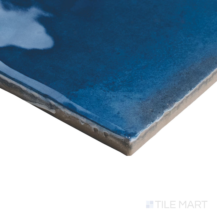 Corner detail of Granadella Marino tile with deep blue gloss wrapping around its square porcelain edge.