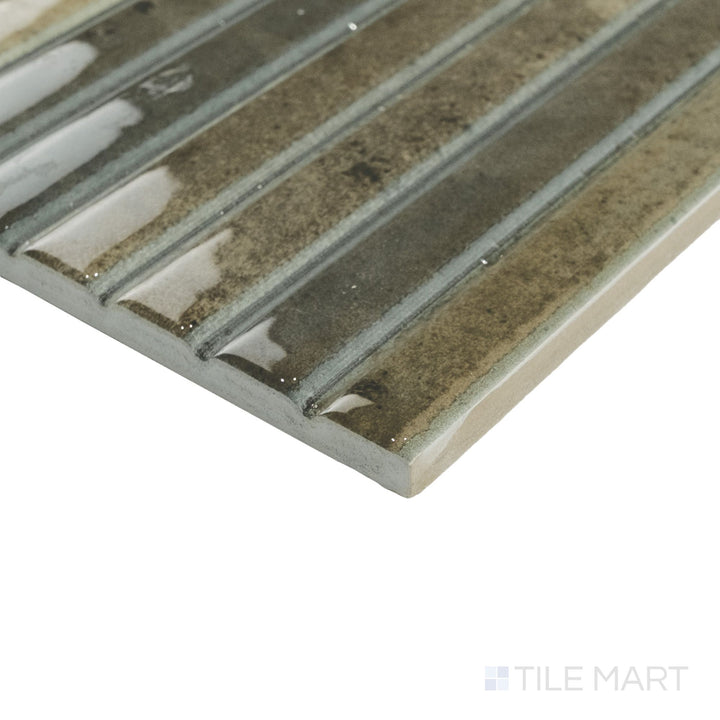 Angled corner shot of Kit Kat Musgo mosaic showcasing earthy green tones and glossy vertical sticks near the edge.