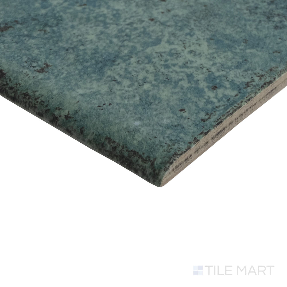 Corner shot of Tahiti Emerald 6x6 bullnose tile showing matte texture and rounded edge profile.