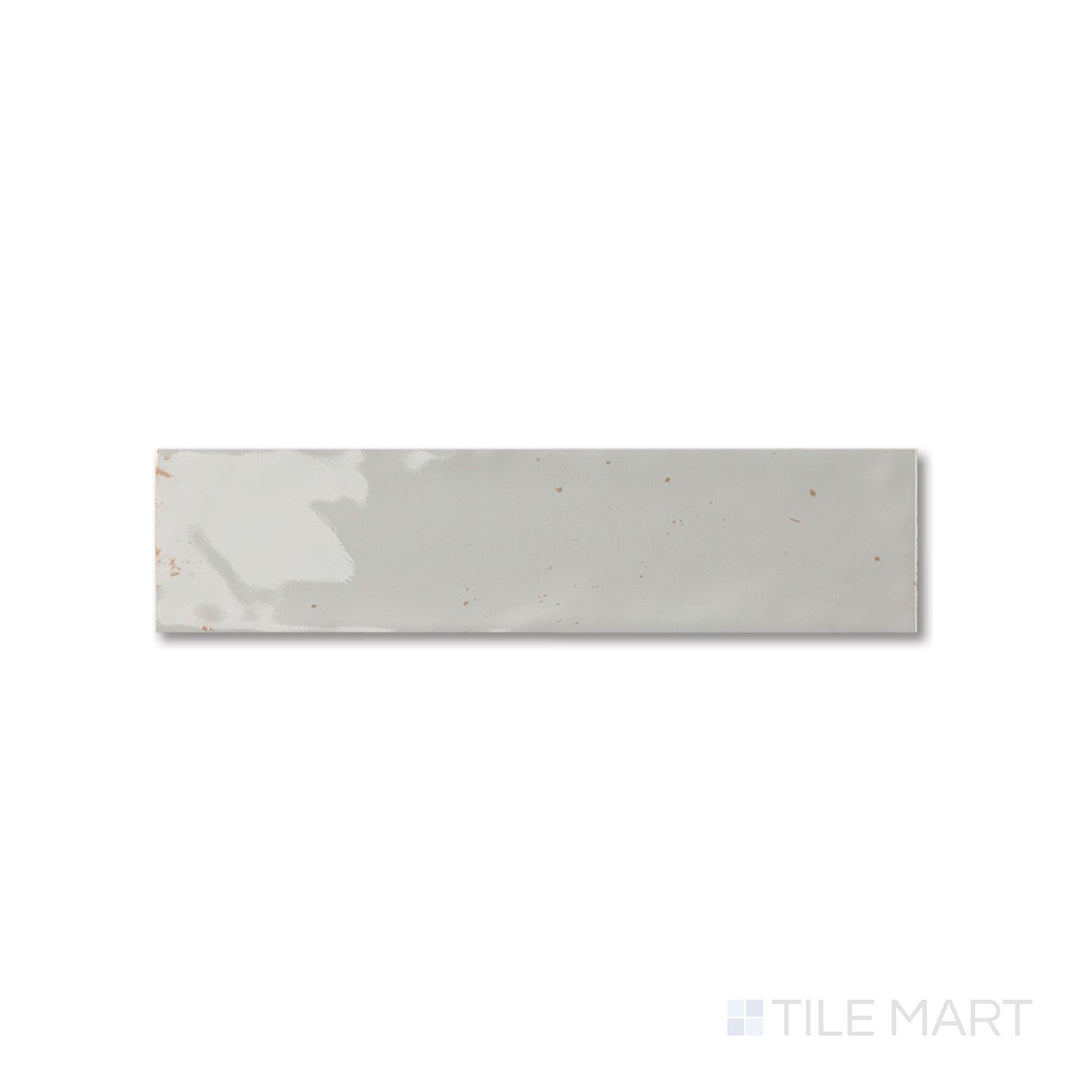 Top-down perspective of Agadir Niebla tile showing a soft misty gray finish and elongated glossy format.