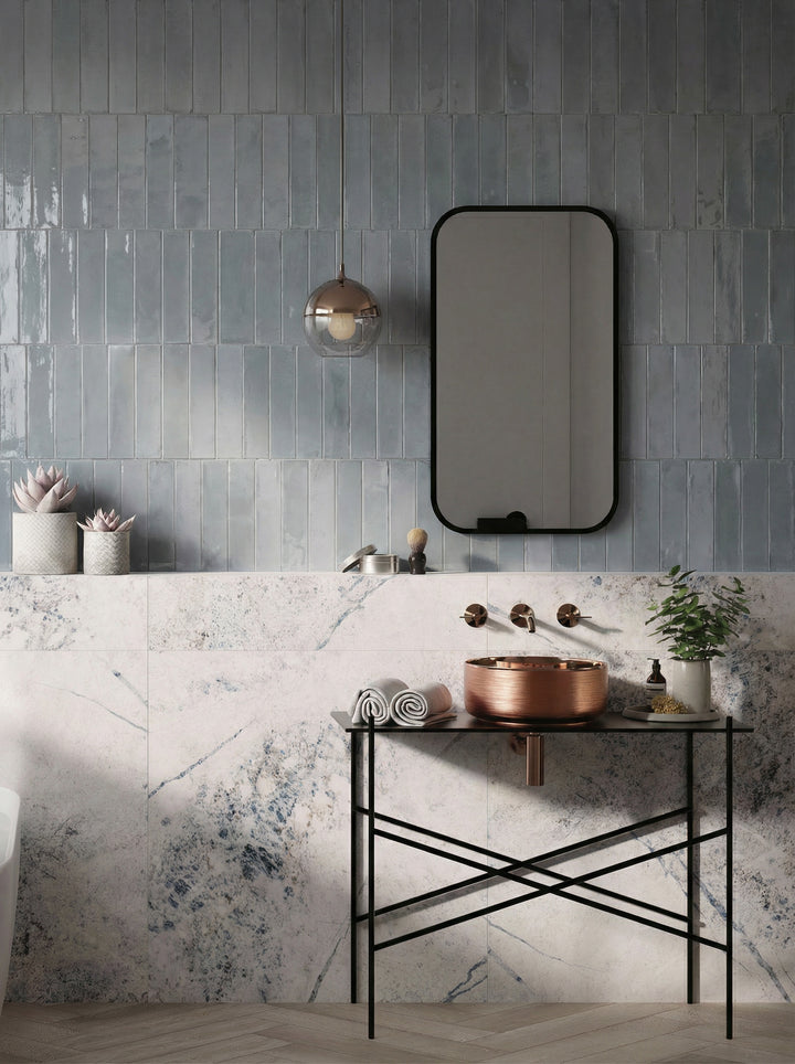 Agadir Piedra 3x11 bright porcelain tile with a natural stone look and reflective surface.