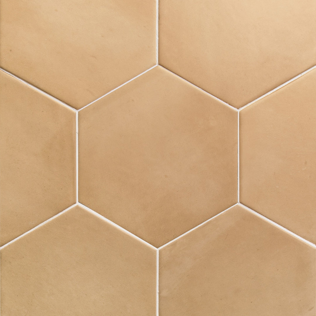 Flat perspective showcasing the hex sand clay tile, sized 7x8, with a reflective sheen that enhances its soft undertone.