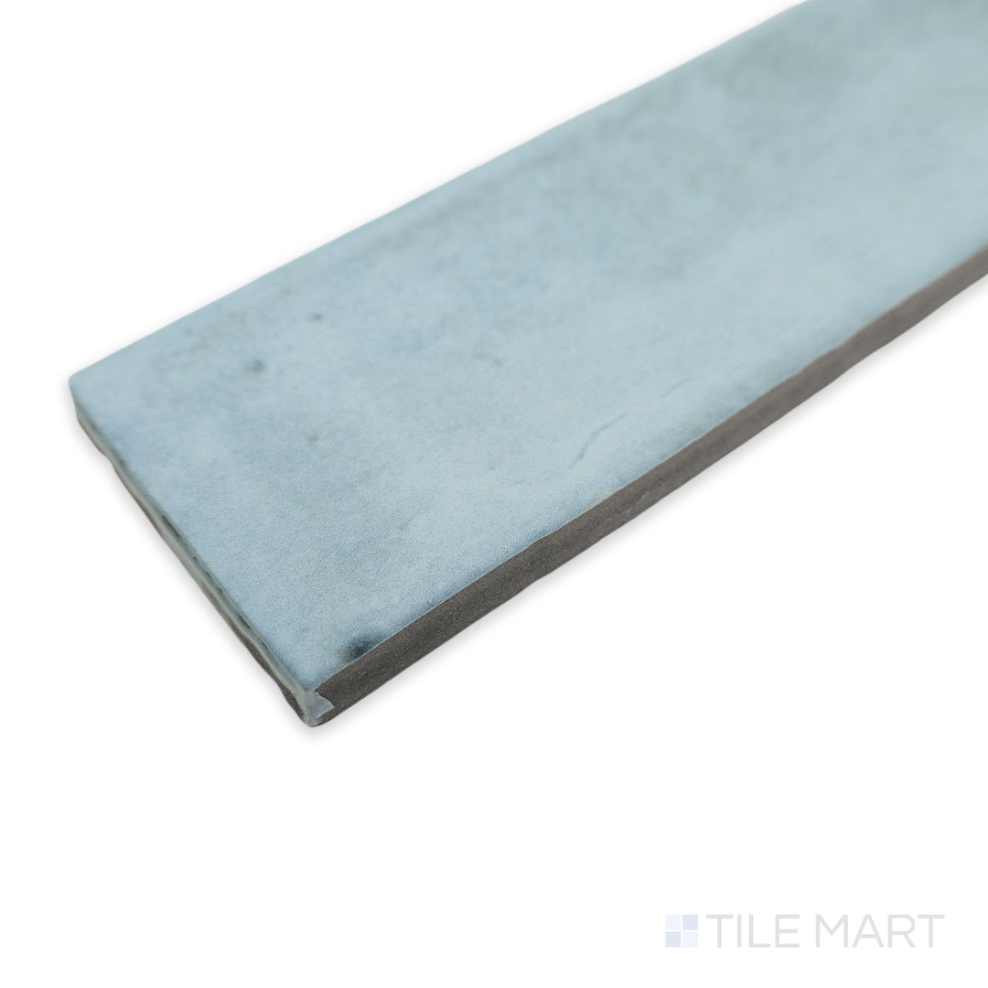 A soft and sophisticated corner view of Soco Light Blue 2x6 matte porcelain tile, showcasing its powdery blue hue and smooth, non-glossy finish.