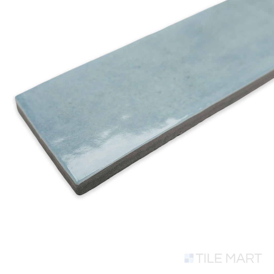 Soco Light Blue 2x6 glossy porcelain tile in a stylish corner perspective, featuring its soft pastel blue shade and a reflective, polished surface.