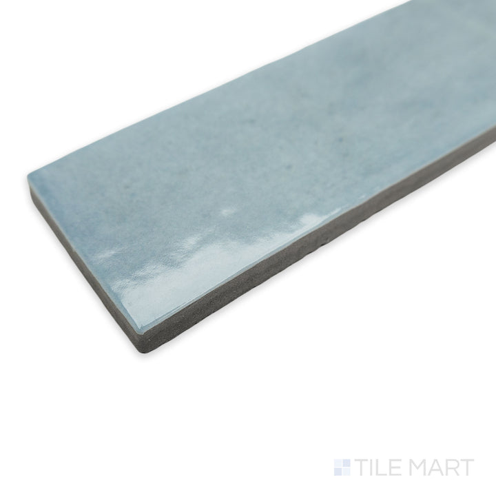 Soco Light Blue 2x6 glossy porcelain tile in a stylish corner perspective, featuring its soft pastel blue shade and a reflective, polished surface.