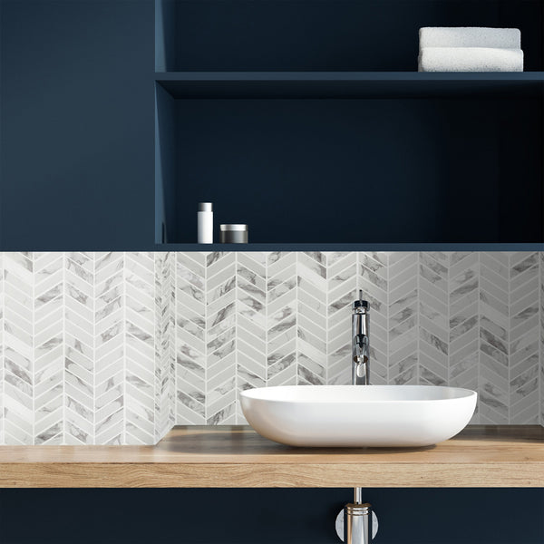 Simple Stone Bianco chevron glass mosaic conveying a bold, graphic movement with its crisp bianco white tone and dynamic V-shaped glass pattern