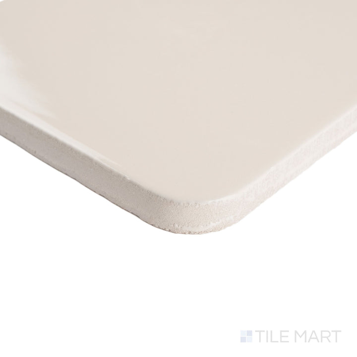 Corner detail of Curves Halo Ivory 6x6 glossy ceramic tile, highlighting its smooth edges and soft ivory finish with a sleek reflective surface