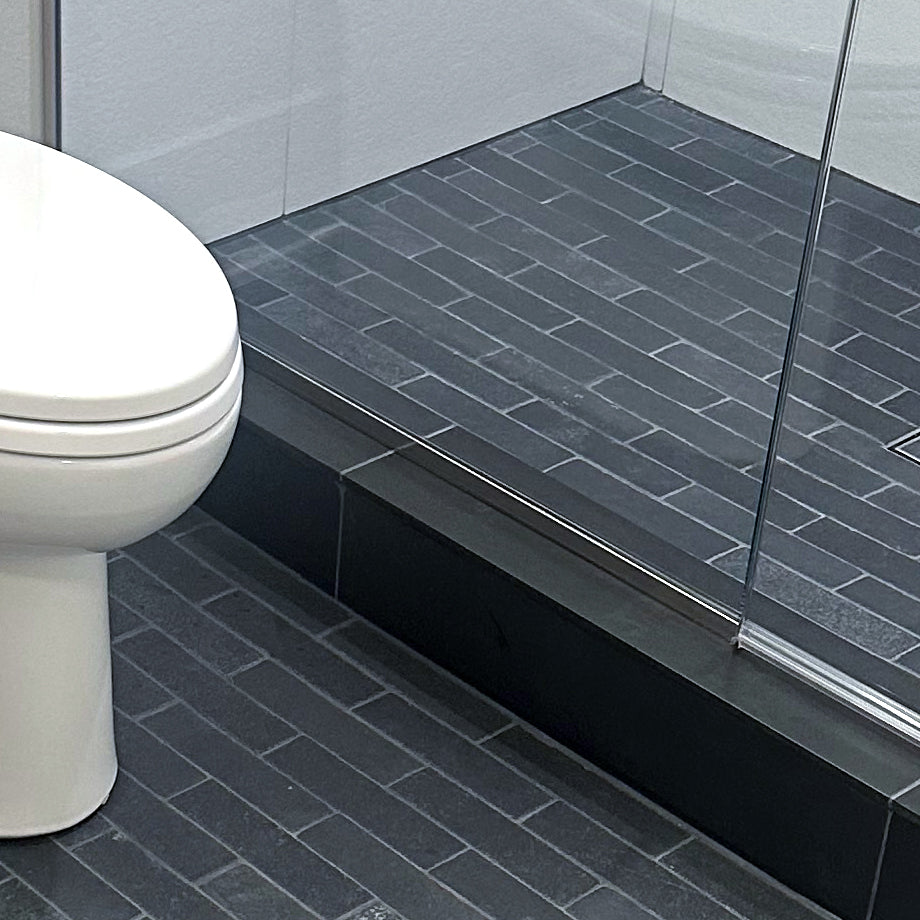 Loose Lime Black 2x8 thin brick limestone featured in an elevated interior with rustic stone character