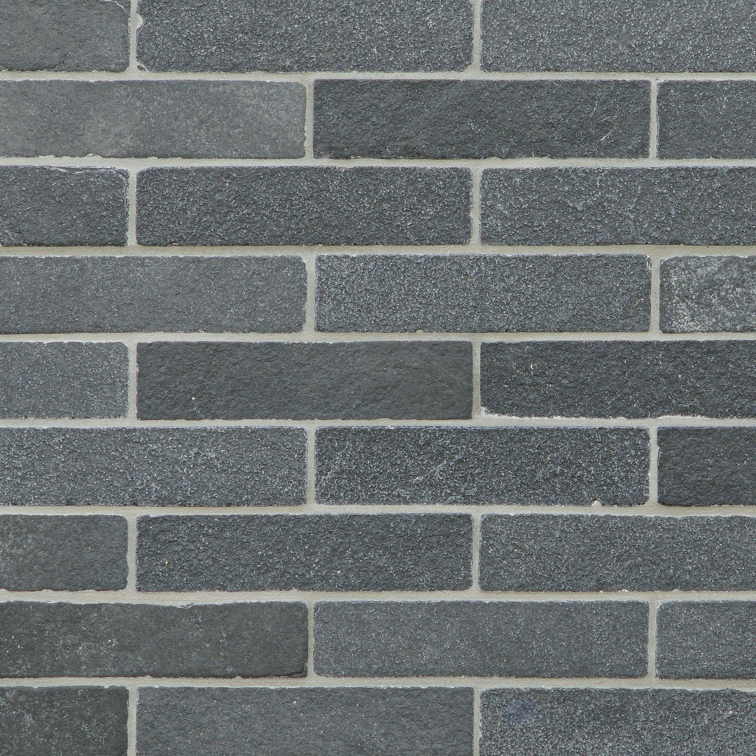 Loose Lime Black 2x8 thin brick limestone with a tumbled finish and organic stone character