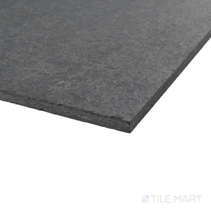 Corner view of flamed and brushed Basalt Black 12x24 tile highlighting textured surface and deep stone tone