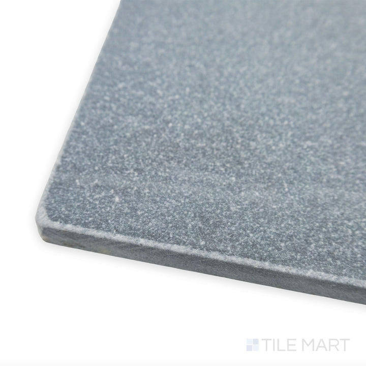 A textured, antique-inspired look is captured in this corner view of Bardiglio Imperiale Bluish Grey 12x12 tumbled marble tile, emphasizing its natural stone character.