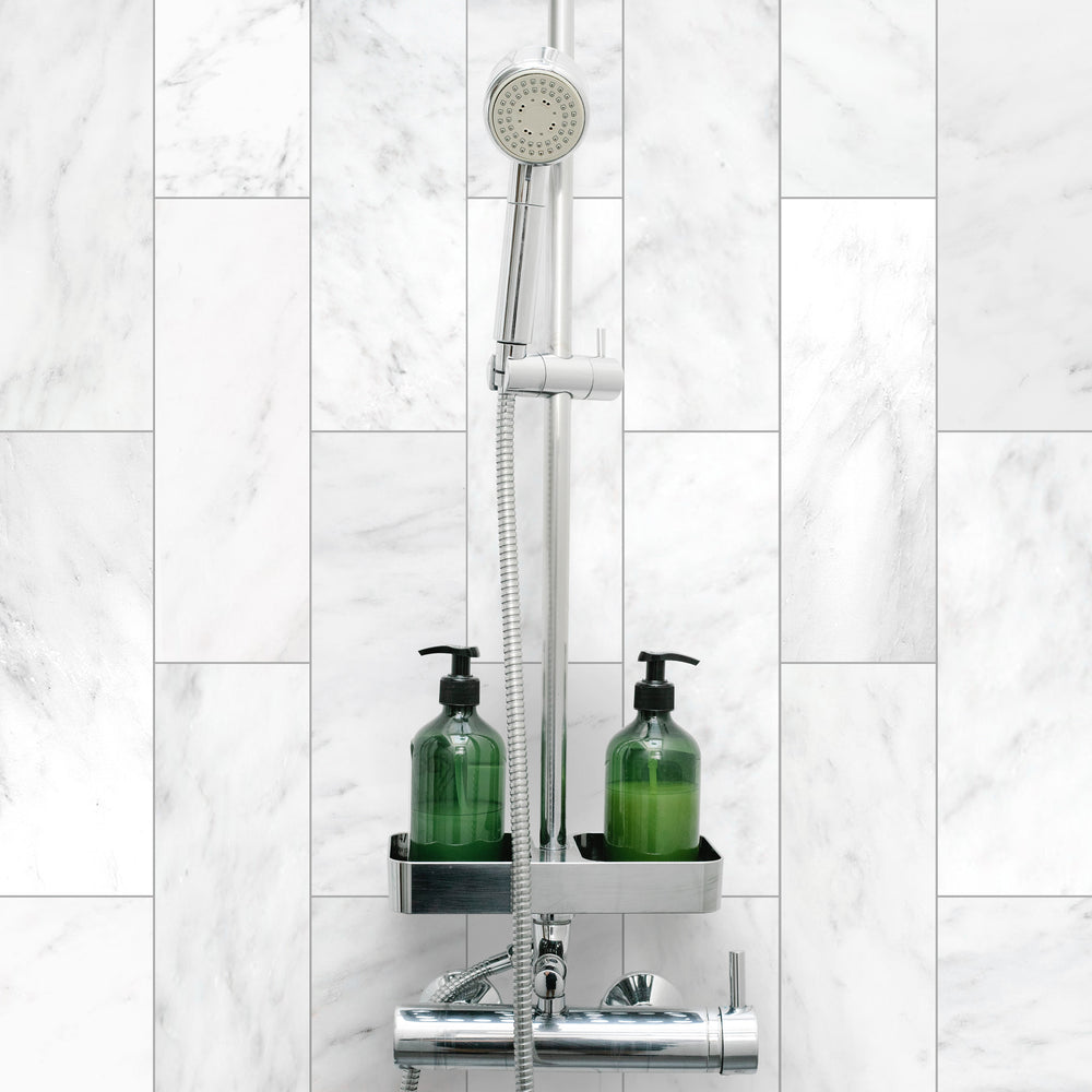 A serene and polished roomscene displaying Oriental White Marble 4X12 Honed, bringing a soft, luxurious touch with its honed surface and natural veining.