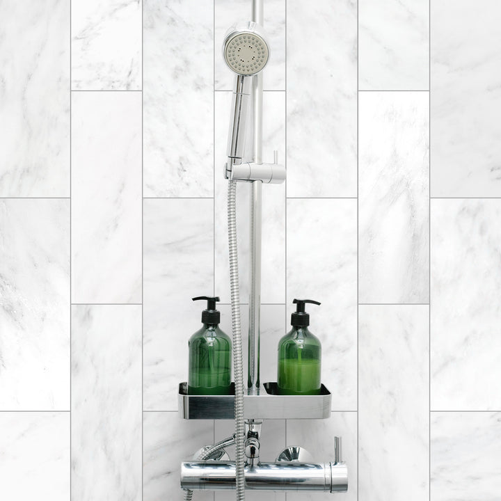 A serene and polished roomscene displaying Oriental White Marble 4X12 Honed, bringing a soft, luxurious touch with its honed surface and natural veining.