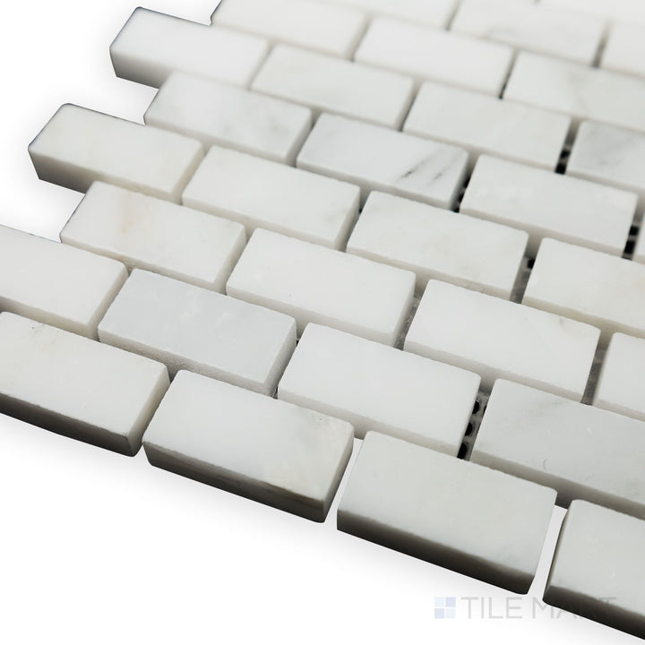 From a side-angled corner view, the Oriental White Marble 5/8x1-1/4 brick honed mosaic highlights its compact brick pattern and soft matte finish for a classic touch.