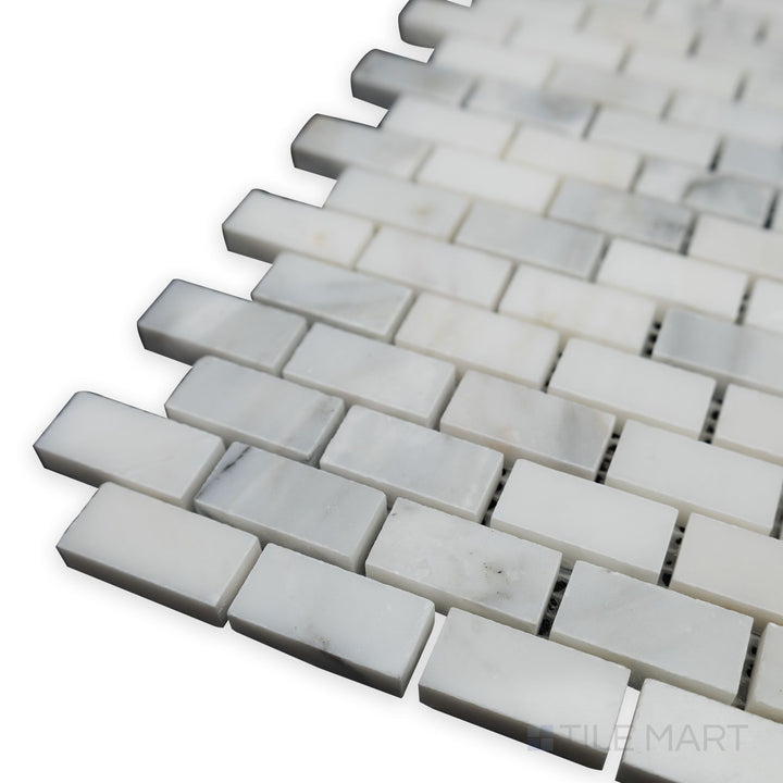 A sleek corner perspective captures the polished surface of the Oriental White Marble 5/8x1-1/4 brick polished mosaic, showcasing its refined brick layout and glossy sheen.