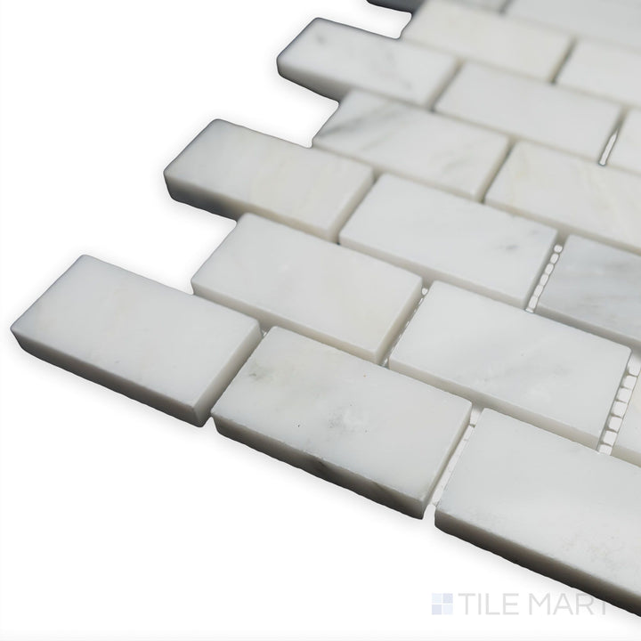 With a polished and structured look, this corner shot of Oriental White Marble 1x2 brick polished mosaic highlights its crisp white tones and clean brick arrangement.