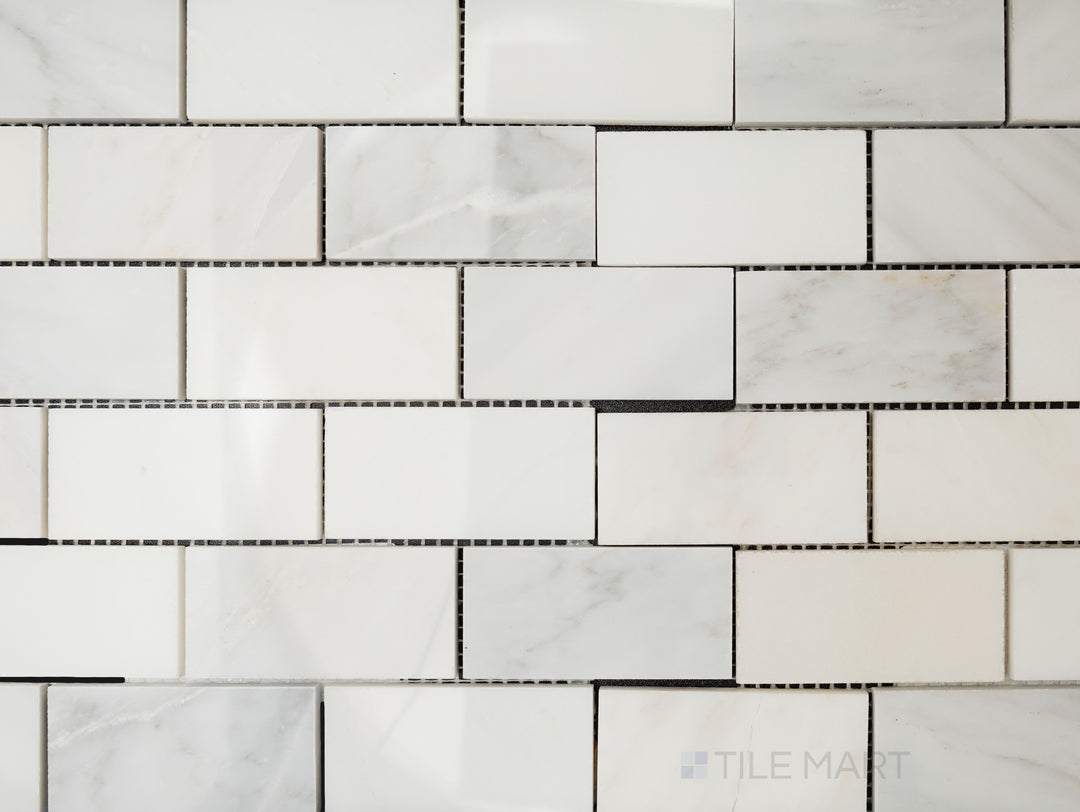 Overhead image of Oriental White Marble 2x4 brick polished mosaic, featuring a reflective surface that enhances its rectangular brick pattern.