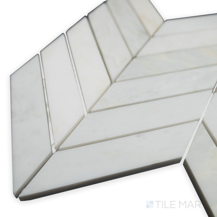 A geometric elegance is revealed in this corner shot of Oriental White Marble 1x4 chevron honed mosaic, where its V-shaped pattern and honed finish create a sophisticated feel.