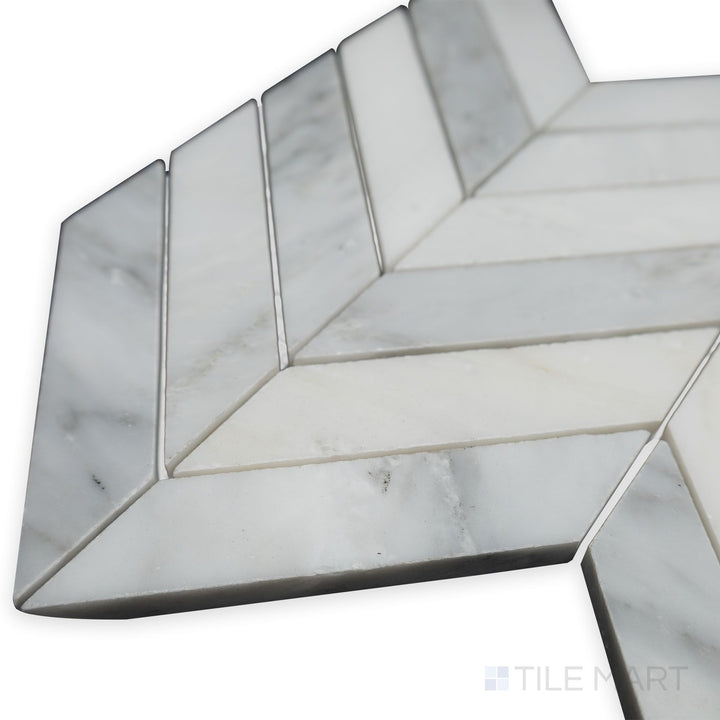 With a polished and sleek appearance, this side-angle corner shot of Oriental White Marble 1x4 chevron polished mosaic enhances its reflective surface and intricate pattern.
