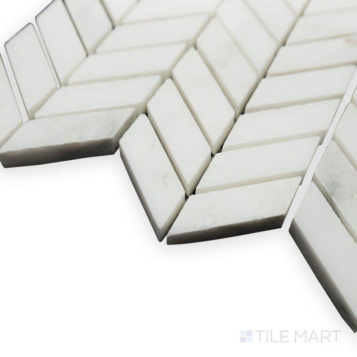 A delicate and intricate design stands out in this corner shot of Oriental White Marble mini chevron honed mosaic, showcasing its precise angles and soft matte finish.