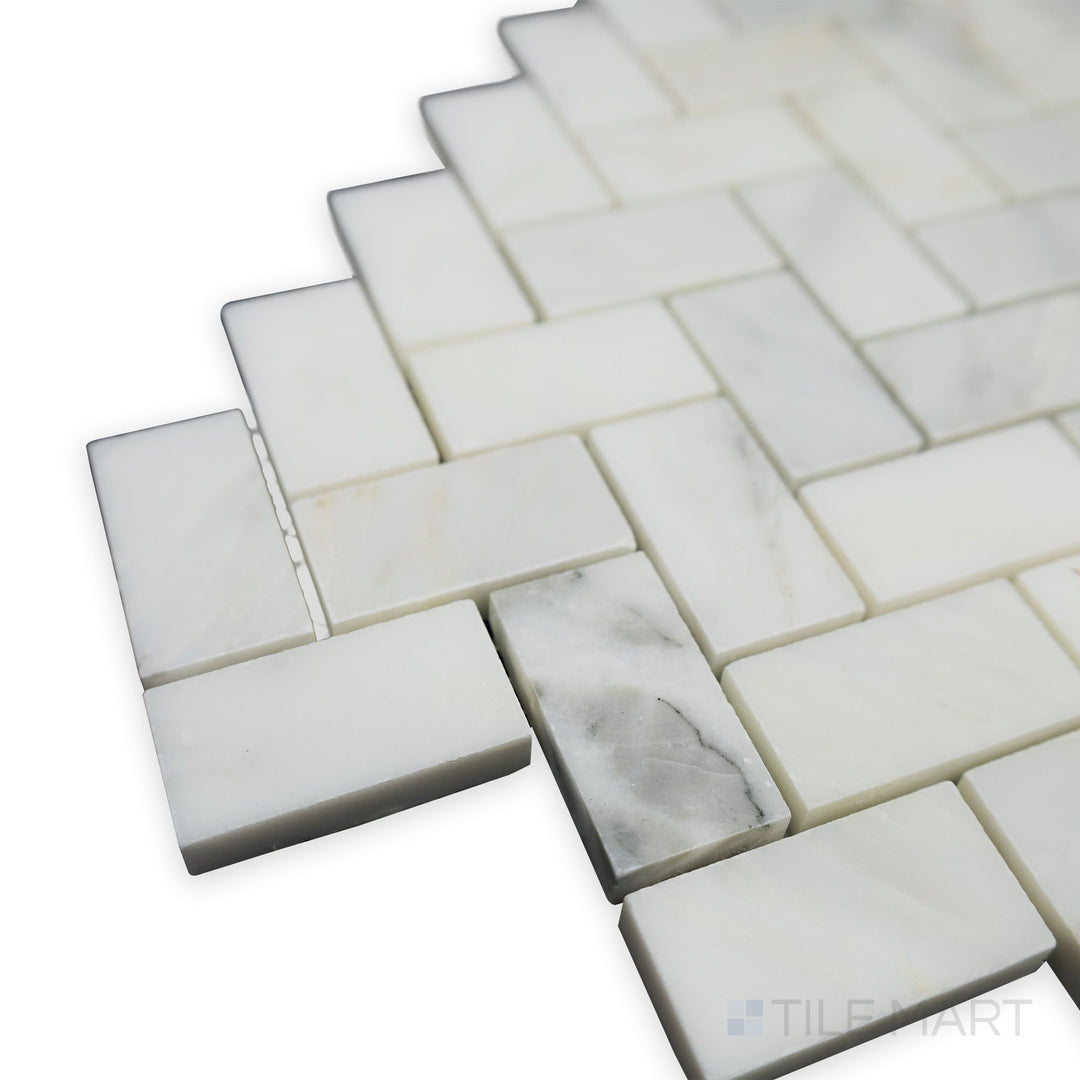 At an elegant angle, the Oriental White Marble 1x2 Herringbone polished mosaic shines, with its high-gloss finish amplifying the brightness of the marble.