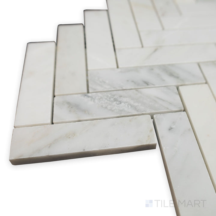 A close-up from the corner reveals the subtle texture of Oriental White Marble 1x4 Herringbone honed mosaic, perfect for a contemporary yet classic look.