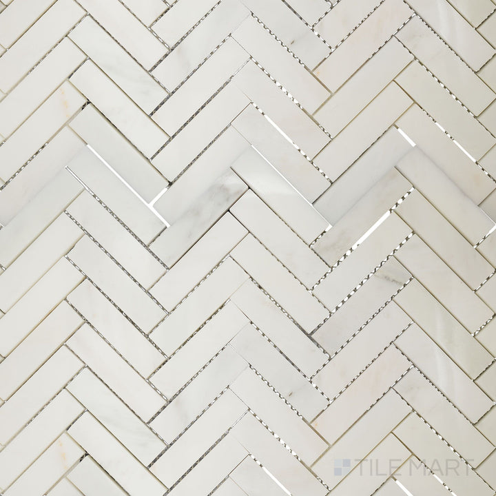 Overhead image of Oriental White Marble 1x4 herringbone polished mosaic, showcasing a glossy finish that enhances the natural veining of the stone.