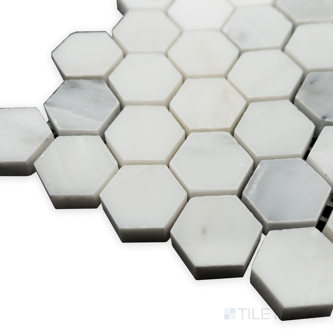 A soft glow enhances the polished surface in this angled corner shot of Oriental White Marble 1" Hexagon polished mosaic, bringing a modern shine to the classic hexagonal shape.