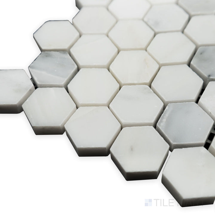 A soft glow enhances the polished surface in this angled corner shot of Oriental White Marble 1" Hexagon polished mosaic, bringing a modern shine to the classic hexagonal shape.