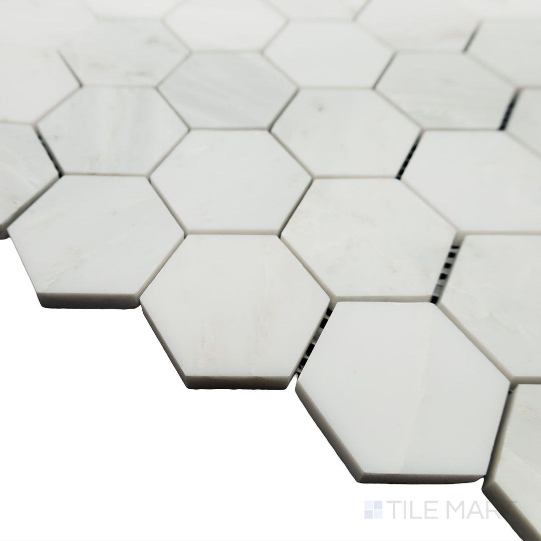 From a stylish side angle, the Oriental White Marble 2" Hexagon honed mosaic highlights its refined pattern with a non-reflective surface for a subtle elegance.