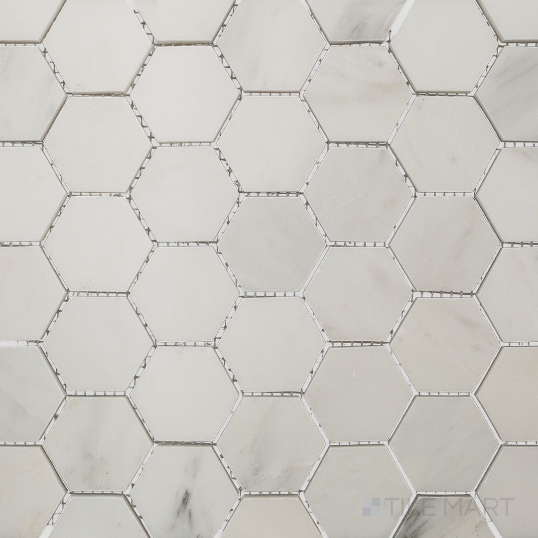 Flat-lay shot of Oriental White Marble 2" hexagon polished mosaic, featuring a sleek polished finish that enhances the natural color variations.