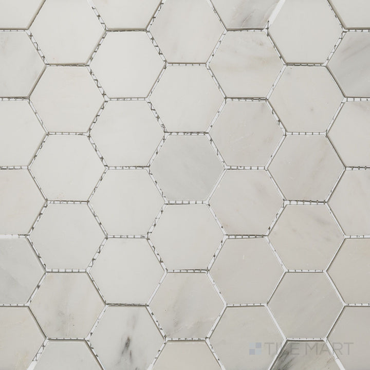 Flat-lay shot of Oriental White Marble 2" hexagon polished mosaic, featuring a sleek polished finish that enhances the natural color variations.