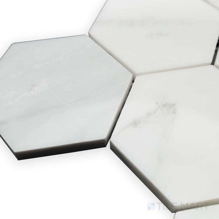 A glossy elegance is captured in this softly angled corner view of Oriental White Marble 3" Hexagon polished mosaic, reflecting natural light beautifully.