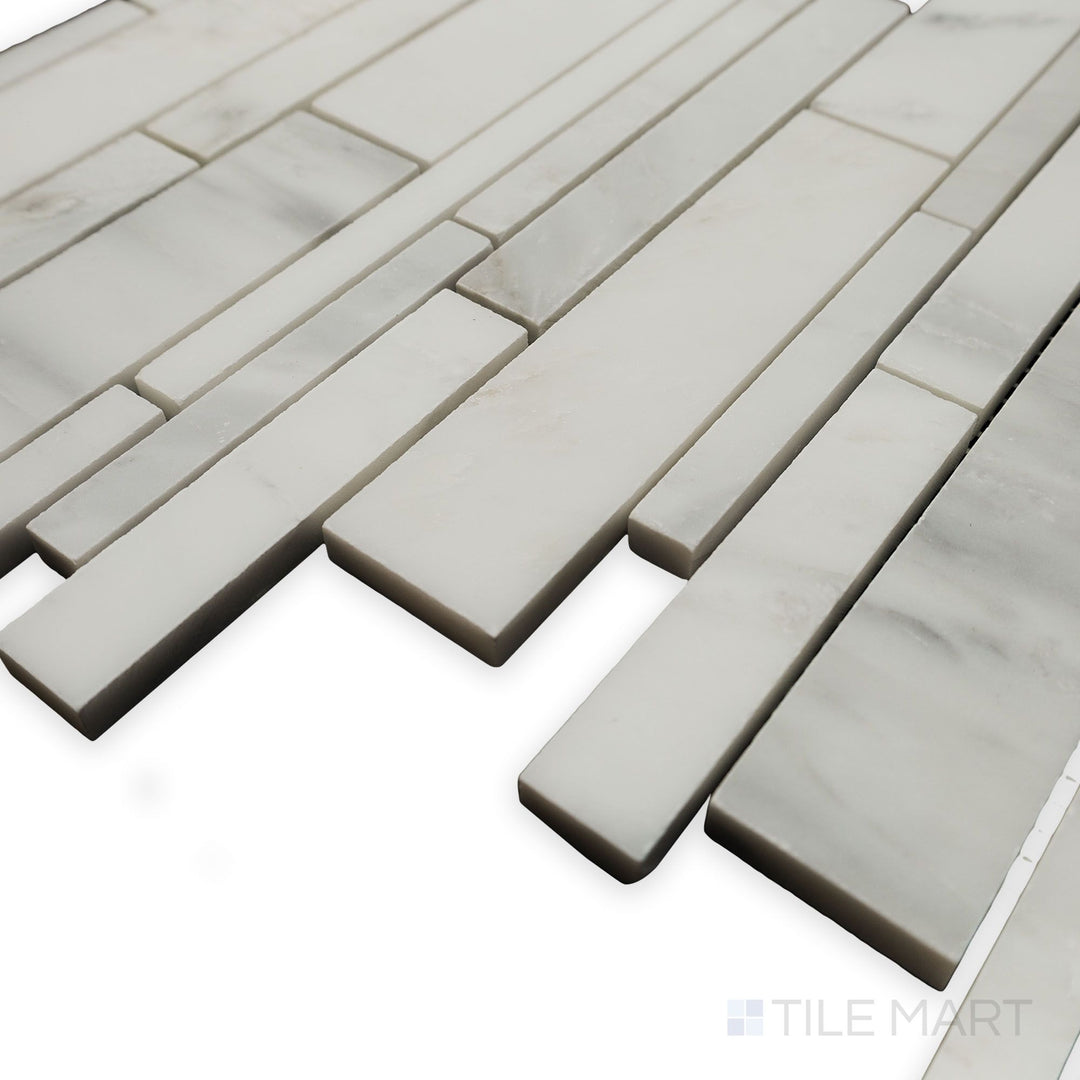 From a sleek side angle, the Oriental White Marble Linear honed mosaic emphasizes its continuous flow and subtle matte finish for a minimalist appeal.